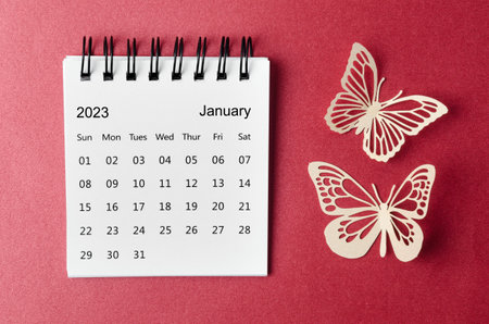 January 2023 desk calendar for the organizer to plan and reminder with paer butterfly on red background.の写真素材