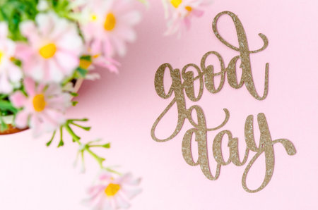 Pink flowers with text GOOD DAY on pink colour background.の写真素材