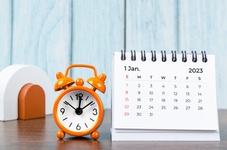 January 2023 Monthly desk calendar for the organizer to plan 2023 year with alarm clock on wooden table.の写真素材