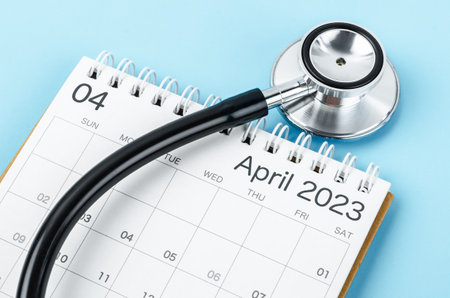 April 2023 deskcalendar and medical stethoscope medical on blue background, schedule to check up healthy concepts.の写真素材