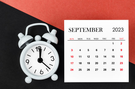 September 2023 Monthly calendar year with alarm clock on red and black background.の写真素材