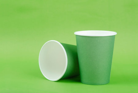 Green paper cup for takeaway on a green color backgroundの写真素材