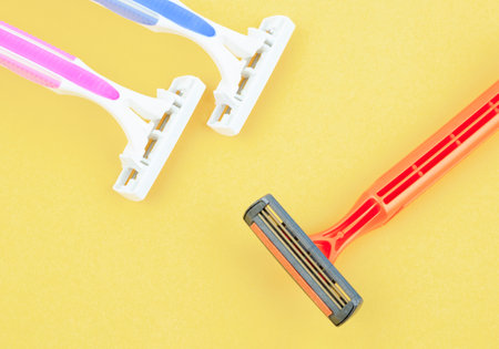 Group of plastic, disposable razors on yellow background.の写真素材
