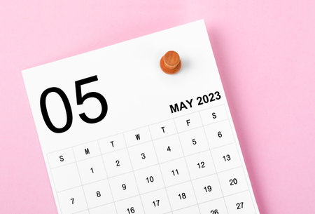 May 2023 calendar and wooden push pin on pink colour background.の写真素材