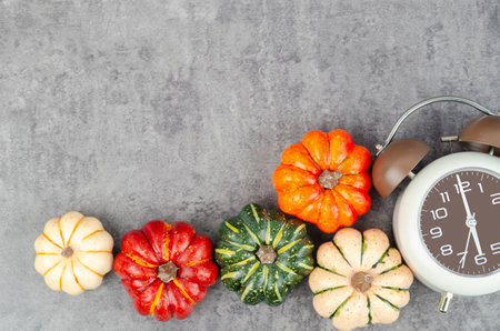 Top view of Pumpkins and an alarm clock on a rustic black table with copy space for your text.の写真素材