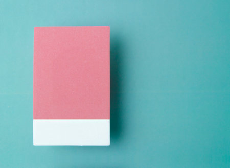 Blank adhesive sticky note on a green cardboard background with copy space for your text or message.