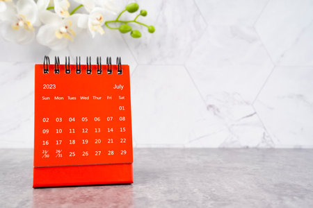 Red calendar July 2023. Desk calendar for year 2023 and white orchid.の写真素材