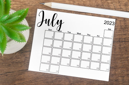 July 2023 Monthly calendar for 2023 year with wooden pencil on wooden table.
