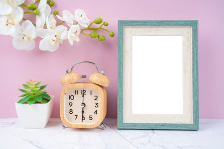 Blank picture frame and alarm clock on black floor with copy space and clipping path for the inside.の写真素材