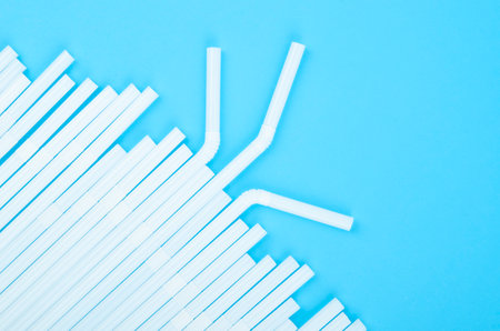 Group of plastic white drinking straw on blue background