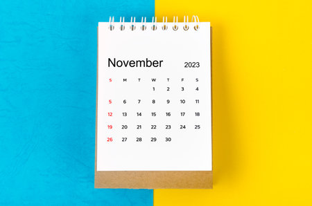 November 2023 Monthly desk calendar for 2023 year on blue and yellow background.の写真素材