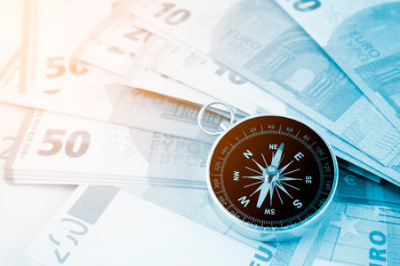 Compass on top of Assorted denominations of Euro bills. Business concepts.の写真素材