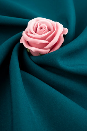 Beautiful pink rose on green color satin background.の写真素材