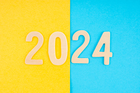 Number 2024 made from wooden on yellow and blue background.