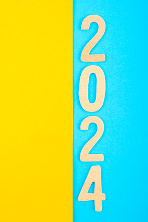Number 2024 made from wooden on yellow and blue background.の写真素材