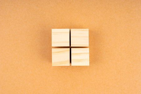 Pyramid of four blank wooden cubes, on brown background.の写真素材
