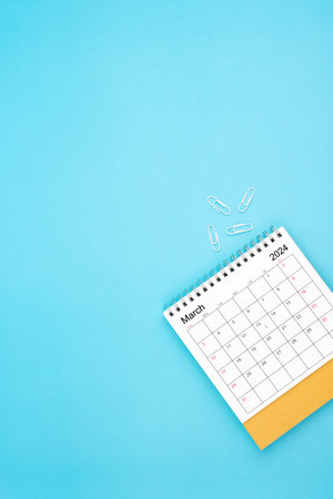 Desk calendar for March 2024 and white paper clip on a light blue color backgroundの写真素材