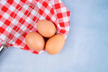Close - up raw chicken eggs with tablecloth on wooden background.の写真素材