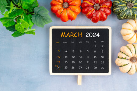 View from above to simple March 2024 calendar decorated with pumpkin and green leaves.の写真素材
