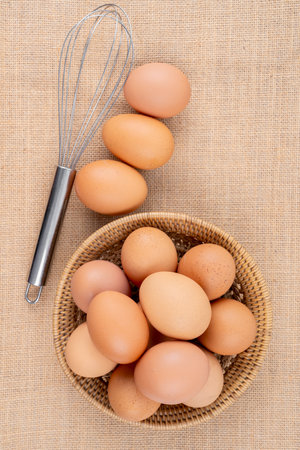 Fresh organic eggs in weave basket on sack background.の写真素材