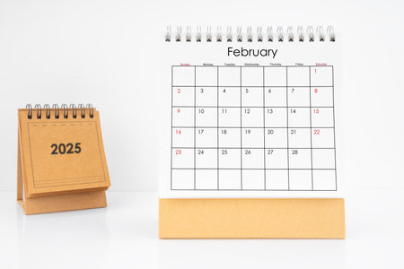 Monthly desk calendar February 2025 year on white table with white background.の写真素材