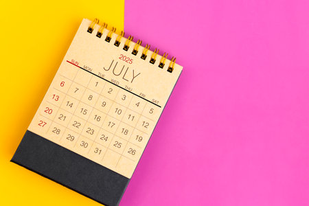 July 2025 desk calendar made from brown paper page on multicolor paper background.の写真素材