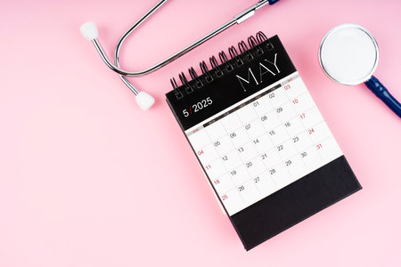 May 2025 desk calendar and stethoscope, Medical appointment schedule to check up.の写真素材
