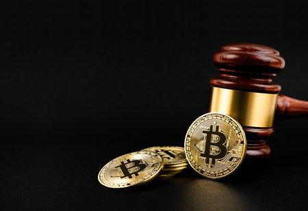 Bitcoin cryptocurrency  with wooden hammer or judge gavel on black background.