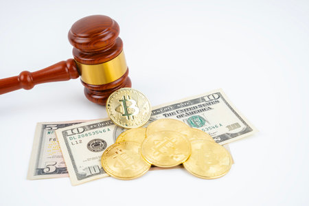 Judge gavel and bitcoins with USD banknotes on white background.の写真素材