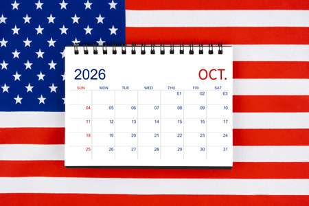 Blank October 2026 desk calendar on United States of America flag.