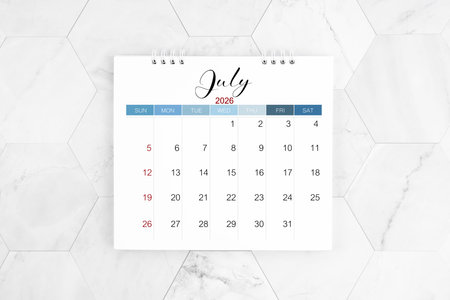July 2026 blank desk calendar on white marble table, Flat lay.の写真素材