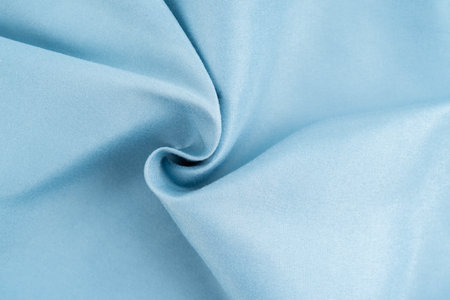 Light blue fabric background of satin silk wallpaper texture cotton canvas linen cloth pattern.