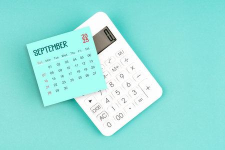 September 2025 calendar card with calculator on blue color background.の写真素材