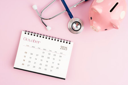 October 2025 desk calendar and stethoscope with piggy bank, Savings for health concepts.の写真素材