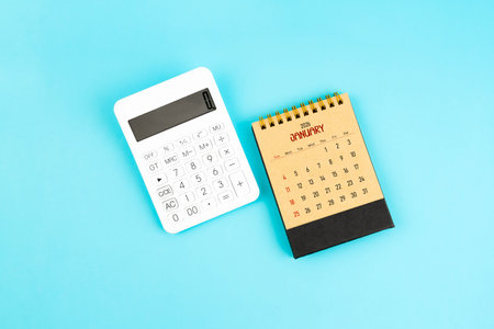 January 2026 brown caculator and white calculator on blue background.の写真素材