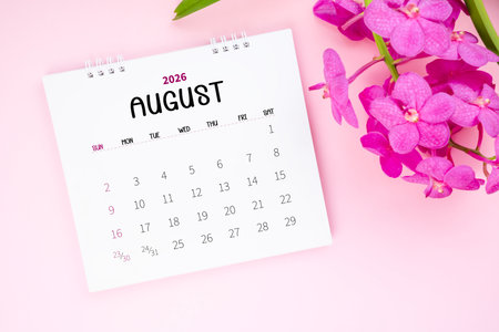 August 2026 desk calendar and pink orchid on pink background.