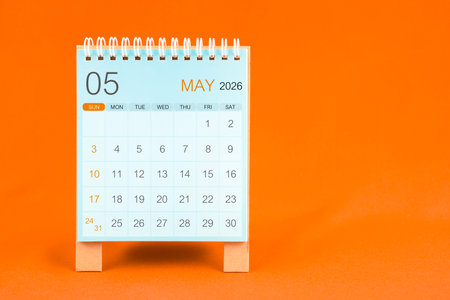May 2026 desk calendar stand on orange textile background.の写真素材