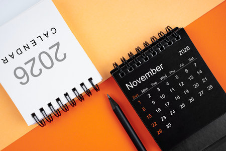 November 2026 desk calendar black and white color with pencil on orange background.の写真素材