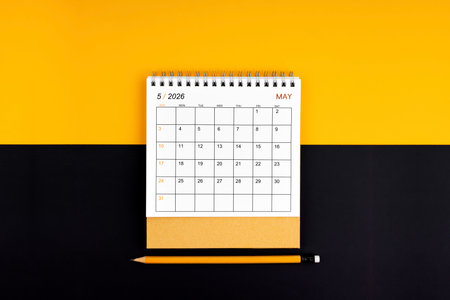 May 2026 desk calendar and pencil on yellow and black color.の写真素材