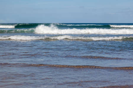 Waves in the ocean on the beach of Xago (Asturias, Spain), blue sky