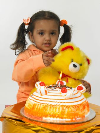asian girl with her teddy bear and birthday cakeの写真素材