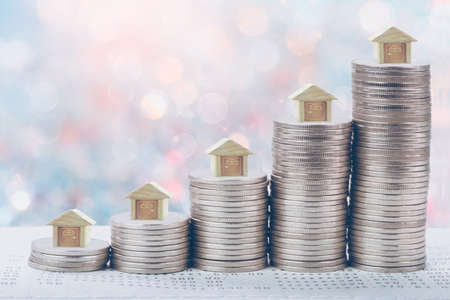 Coins stack in front of bank account book Savings money of coins concept concept for property ladder, mortgage and real estate investment.  for saving or investment for a house, retirementの写真素材