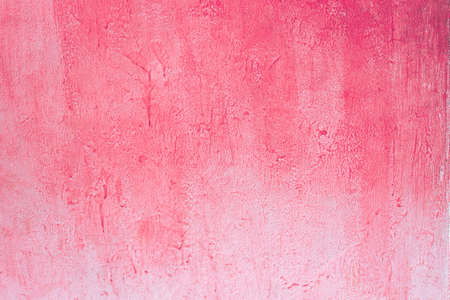 Pink concrete wall.Worn pale pink concrete wall texture background with a bit of vignetting, paint partly faded.の写真素材