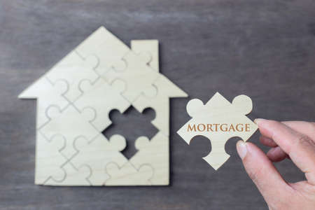 Wooden puzzle wait to fulfill home shape for build dream home, happy life, house or mortgage investment conceptの写真素材