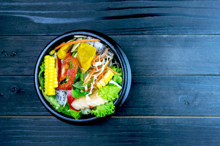 Fresh salad with chicken, tomatoes and mixed greens,corn salad, (arugula, mesclun, mache) Home made food. Concept for a tasty and healthy meal. on wooden background close up. Healthy food.の写真素材