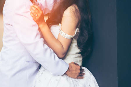 Close-up of a bride and groom  kissing on a wedding night in the bride's hand is wearing a wedding ring and the wedding dress is specially made, this is their first wedding.の写真素材