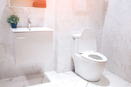 White toilet bowl in the bathroom with bright tiles with toilet and sink.の写真素材