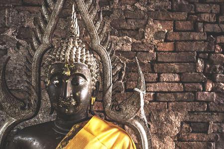 Big buddha statue at Brick wall background.の写真素材