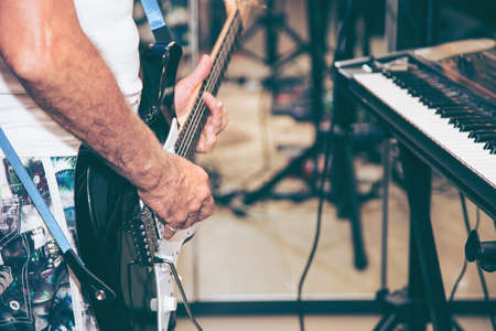 Close up of man hand playing guitar on stage for background.の写真素材