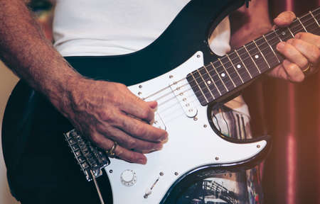 Close up of man hand playing guitar on stage for background.